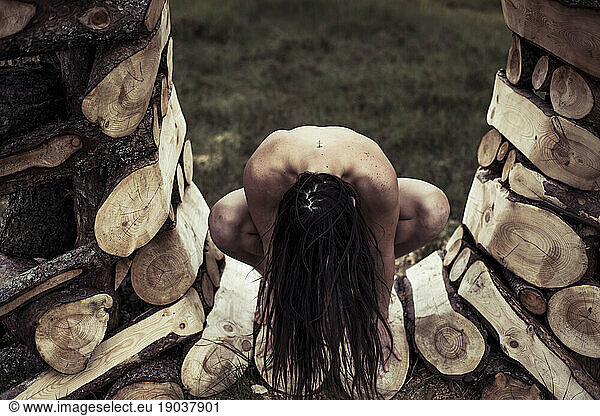 Nude dancer sits in wooden sculpture