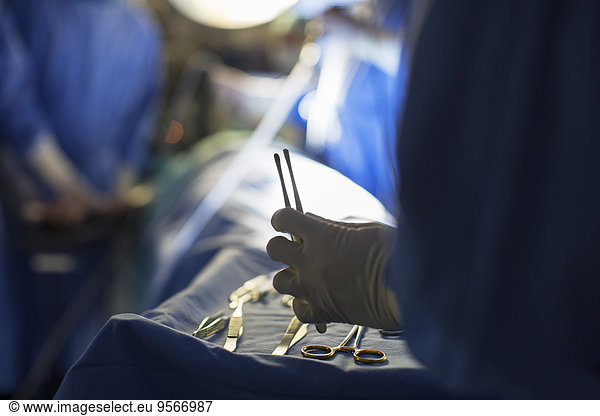 Nurse holding surgical tools during surgery