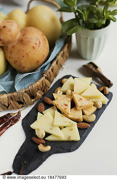 Nuts and slices of Caciocavallo cheese on cutting board