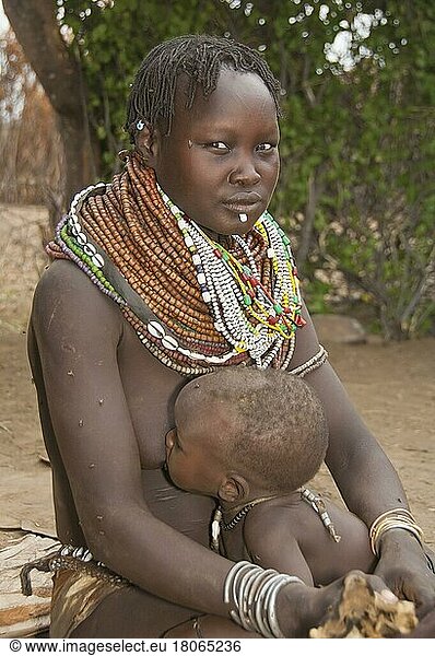 Nyangatom Frau mit Perlenketten  Bume  Buma  Bumi  stillen  stamm  -Stamm  mit Säugling  Omo-Tal  Äthiopien  Afrika