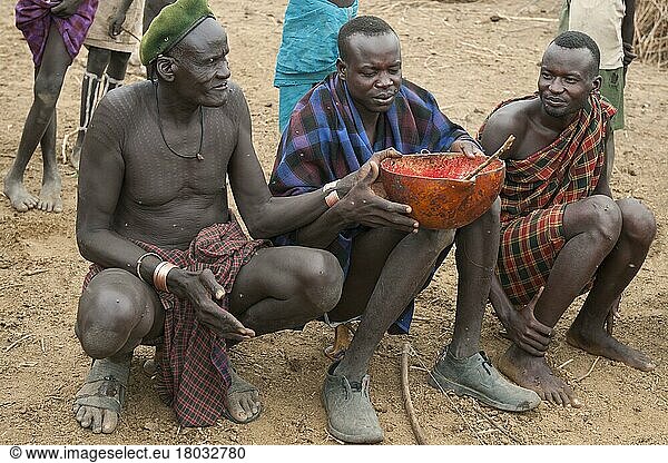 Nyangatom-Männer teilen sich eine Kalebasse mit Kuhblut  Omo-Flusstal  Äthiopien  Bume  Buma  Bumi  Afrika