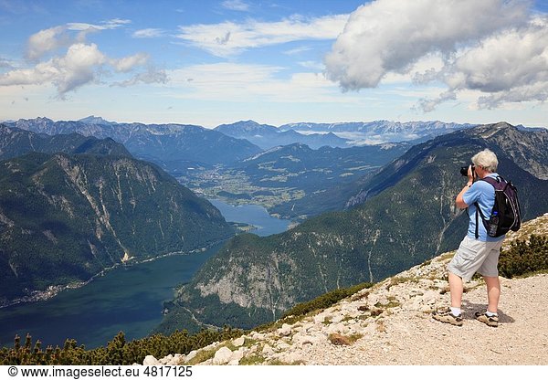 Obertraun  Salzkammergut  Austria  Europe Senior woman photographing the view to Hallstattersee lake from Krippenstein mountain in the Dachstein Massif in the Austrian Alps