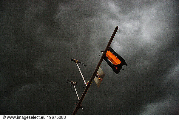 Oblique view of a trafficlight against a stormy sky.