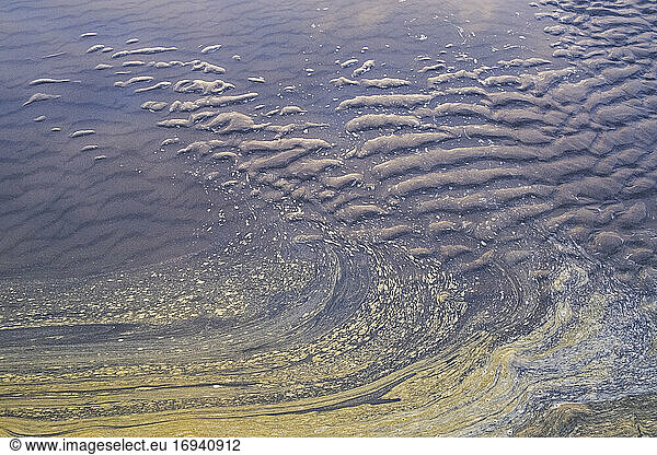 Ocean water and ripple patterns in the sand at low tide.