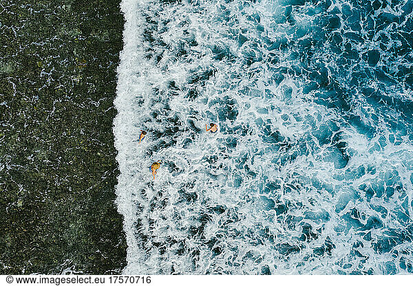 Ocean waves with small faceless people from above