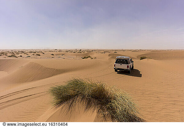 Off-road car in vast barren desert