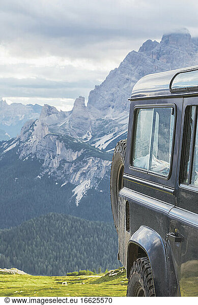 Off-road vehicle against mountain peak seen from Sesto Dolomites  Dolomites  Alto Adige  Italy