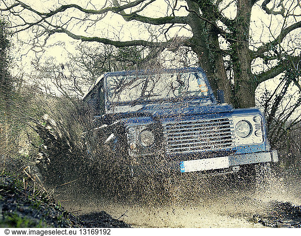 Off road vehicle driving through wet forest  Hampshire  England