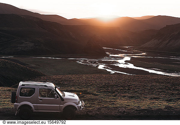 Off road vehicle in desert  sunset over mountain ranges  Landmannalaugar  Highlands  Iceland
