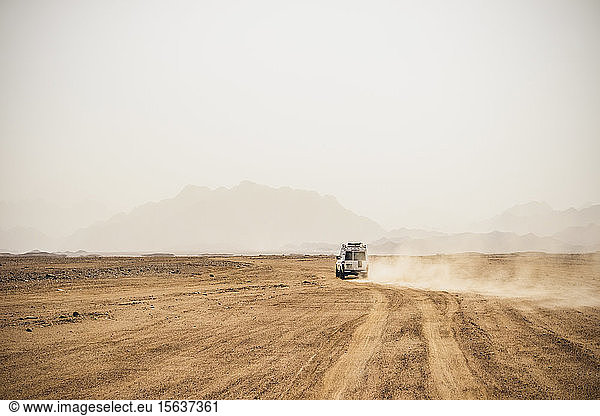 Off-road vehicle moving on arid landscape against clear sky during sunny day  Suez  Egypt