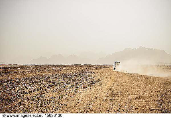 Off-road vehicle moving on arid landscape against clear sky  Suez  Egypt