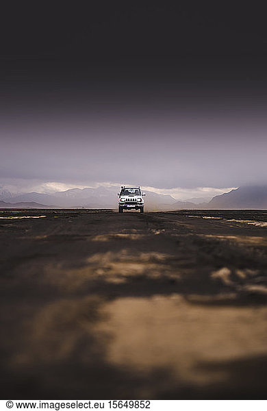 Off road vehicle on dirt track black sky in background Landmannalaugar Iceland