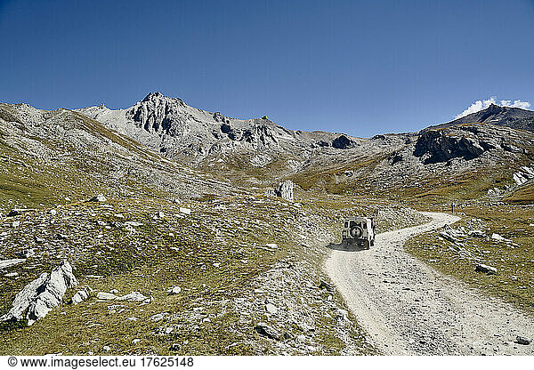 Off-road vehicle on gravel road at sunny day  Colle Sommeiller  Turin  Italy