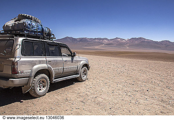 Off-Road Vehicle parked against mountain ranges and clear sky