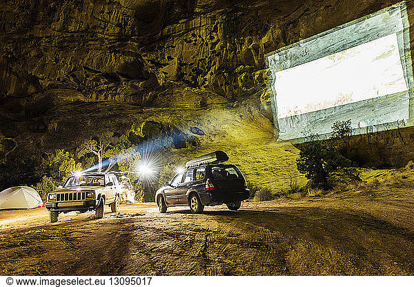 Off-road vehicles with projection screen on mountain at campsite