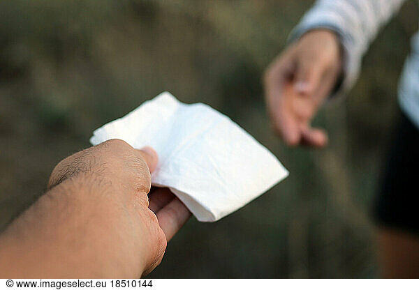 Offering a handkerchief to a woman with a cold.