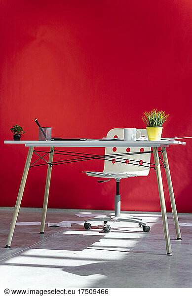 Office desk and red wall in the background