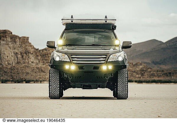 Offroad Vehicle On Salt Flat With Lights On