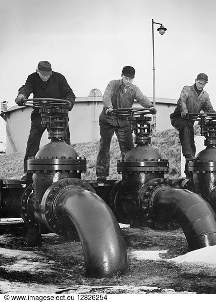 OIL VALVES  c1944. Workers at an Atlantic coast seaport in the United States regulate the flow of oil onto tankers bound for armed forces during World War II. Photographed c1944.