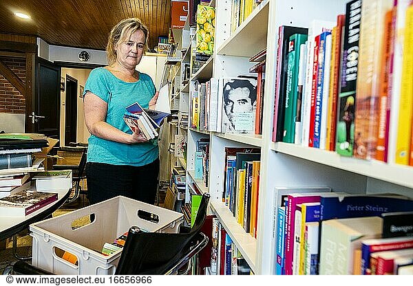 Oisterwijk  Niederlande. Ältere Frau räumt den Kellerraum ihres Landhauses auf  nachdem sie jahrelang Bücher gesammelt hat.