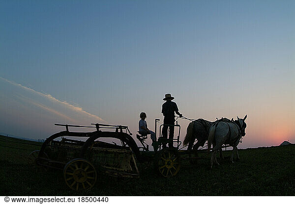 Old Amish Farm with man on plow working fields Lancaster Pennsylvania
