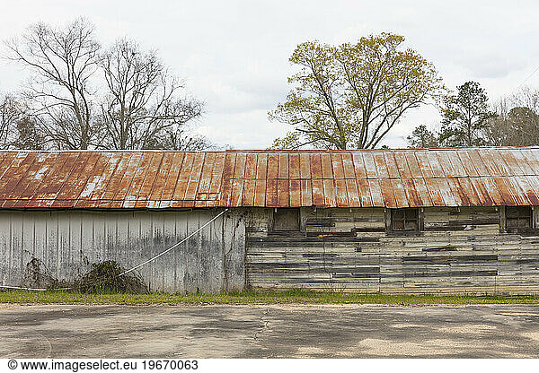 Old barn and warehouse with a rusting roof.