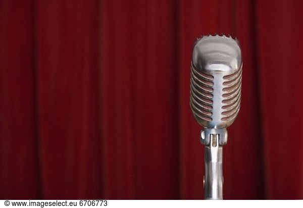 Old fashioned microphone with red curtain