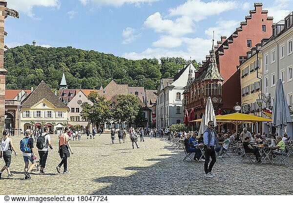 Old guard and historic department stores' on Münsterplatz  in the background the Schlossberg with Schlossberg tower  Freiburg im Breisgau  Baden-Württemberg  Germany  Europe