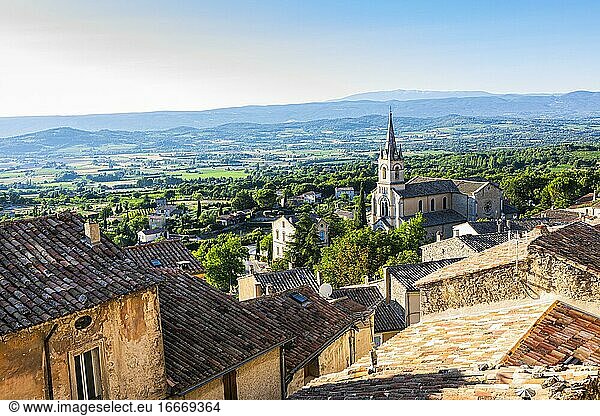 Old houses of Bonnieux  behind them the church Elise neuve  panoramic view over the valley of the Abbot  Luberon  Provence  France  Europe