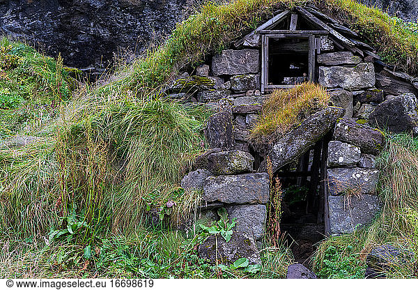 Old hut ruins built form rocks in Iceland with grass covered roof