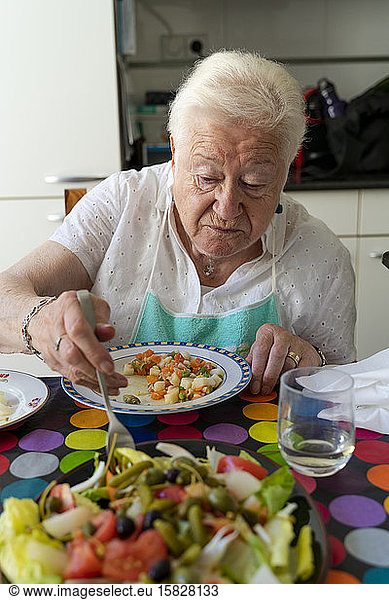 Old lady eating alone healthy food at home