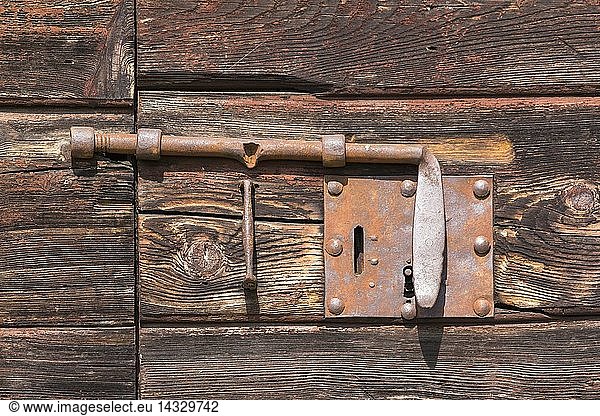 Old lock or latch on wooden door  typically used once in huts or barns of the Dolomites Veneto  Italy