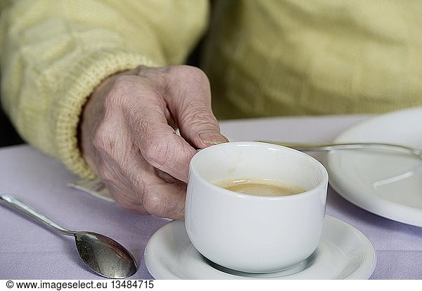 Old man's hand holding a cup of coffee  Germany  Europe