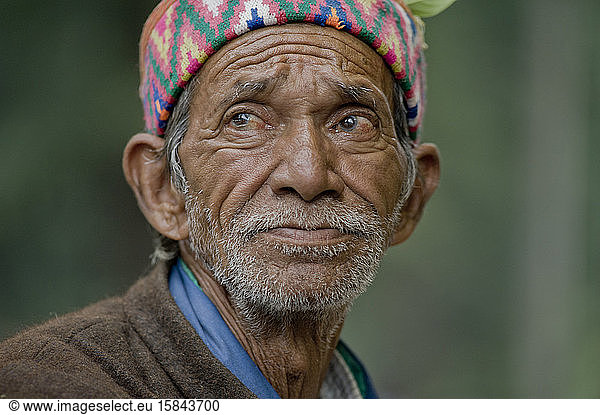 Old man with a traditional Kullu cap staring away