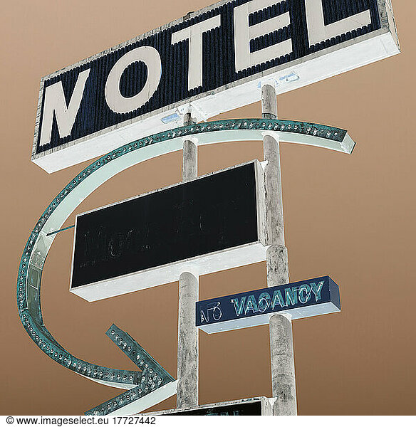 Old rusting Motel sign by the roadside  inverted image.