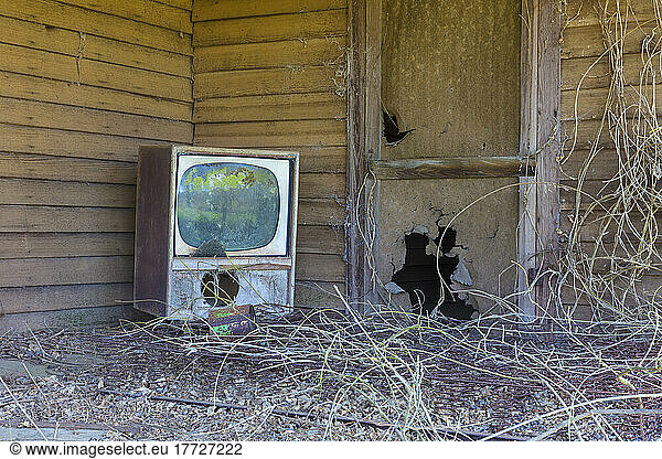 Old TV set on front porch of an abandoned homestead.