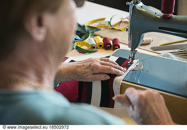 Old woman working at sewing machine
