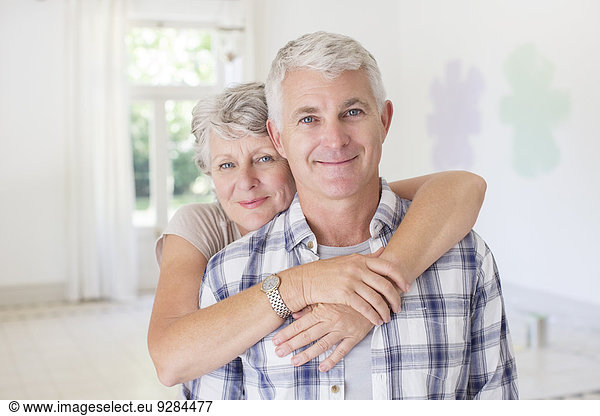 Older couple hugging in living space