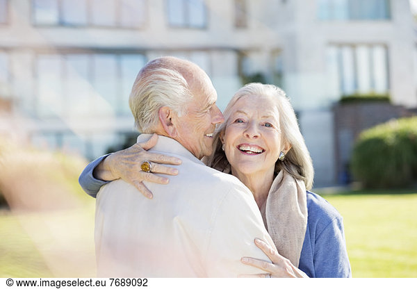 Older couple hugging outdoors
