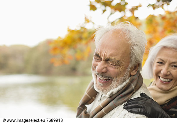 Older couple laughing together in park