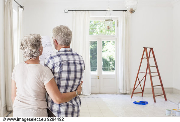 Older couple looking at construction plans together