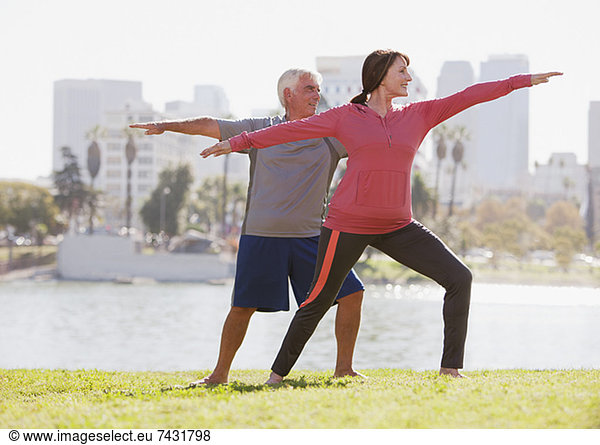 Older couple practicing yoga outdoors