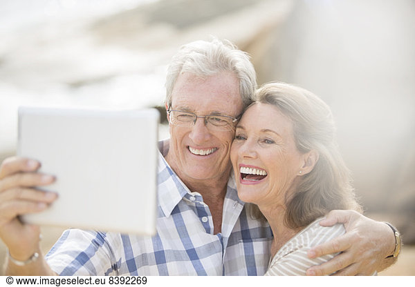 Older couple taking pictures with digital tablet