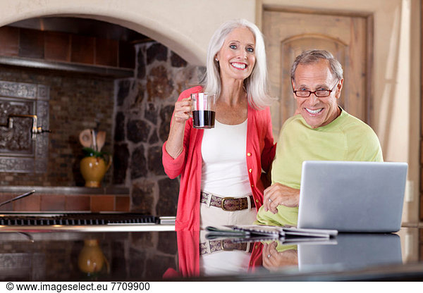 Older couple using laptop at breakfast