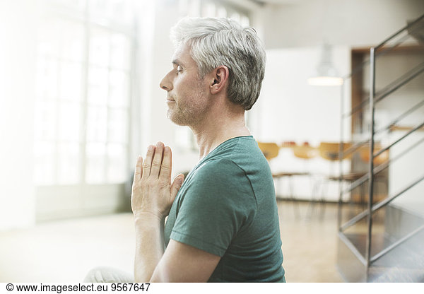 Older man meditating indoors