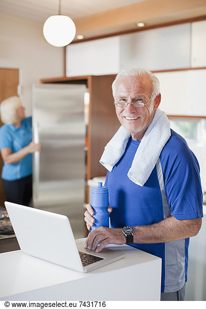 Older man using laptop after workout