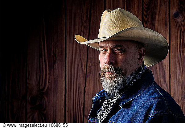 Older man with gray beard wearing a cowboy hat