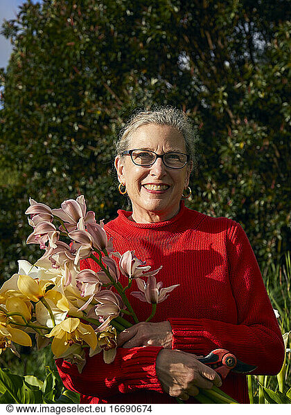 Older Woman Holding Bouquet of Fresh cut flowers in her Garden