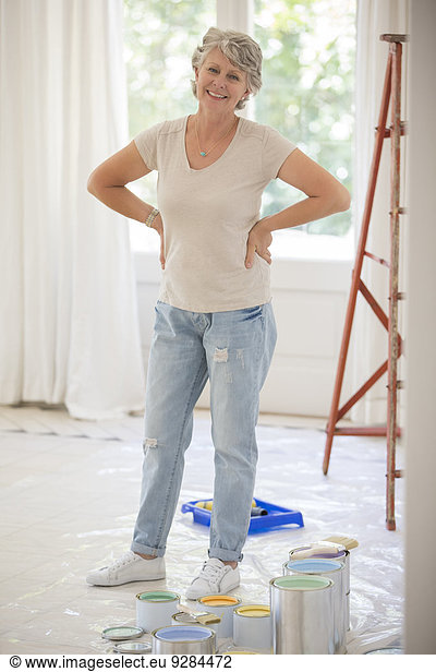 Older woman standing near paint in living space