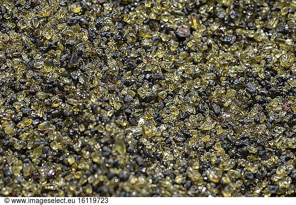 Olivine crystals in the volcanic sand of a beach  Reunion Island